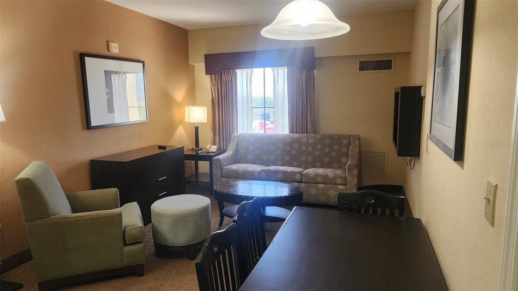 7601 Canada Avenue, Unit 618 Orlando, FL 32819 - Photo 6 of 19 a living room with furniture and a chandelier