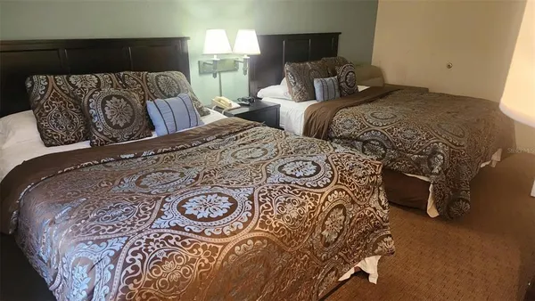 a bedroom with two beds and a lamp