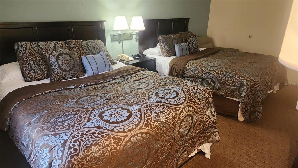 7601 Canada Avenue, Unit 618 Orlando, FL 32819 - Photo 7 of 19 a bedroom with two beds and a lamp