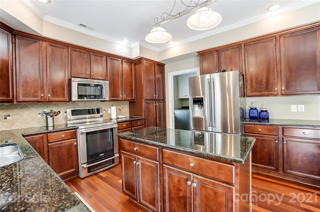 1100 Blacksnake Road Stanley, NC 28164 - Photo 16 of 48 a kitchen with stainless steel appliances granite countertop a refrigerator stove and sink