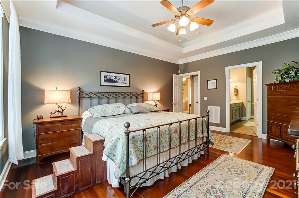 1100 Blacksnake Road Stanley, NC 28164 - Photo 21 of 48 a bedroom with a bed and a chandelier
