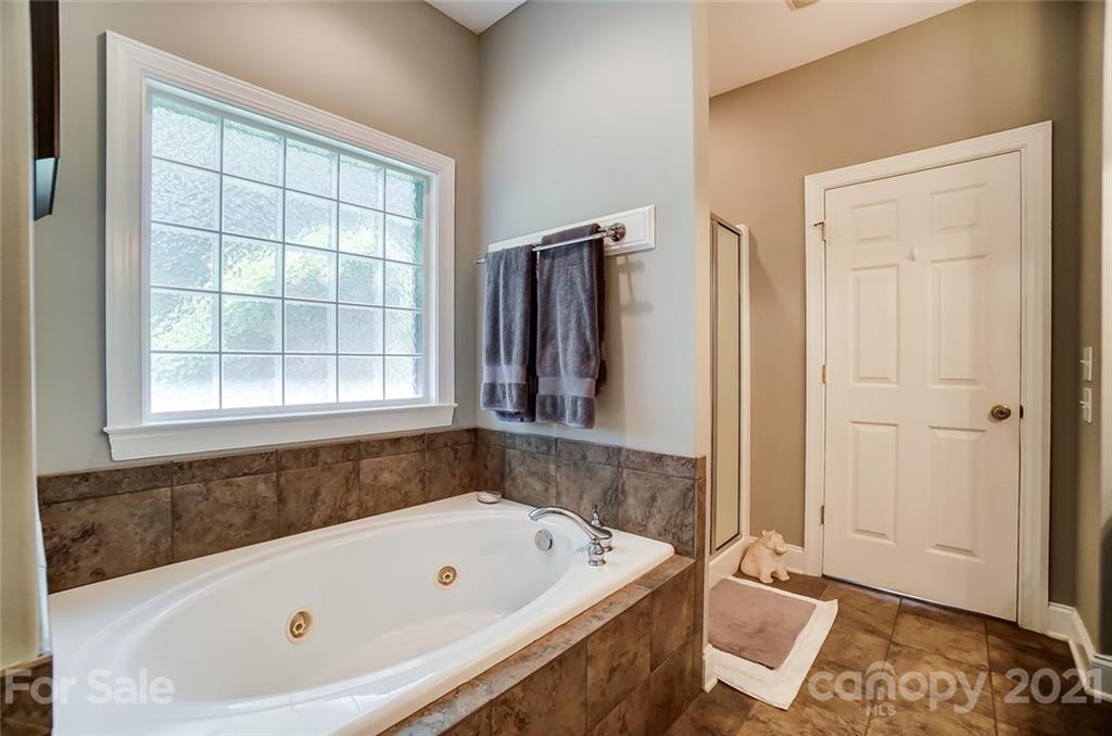 1100 Blacksnake Road Stanley, NC 28164 - Photo 23 of 48 a bathroom with a tub a sink and a window