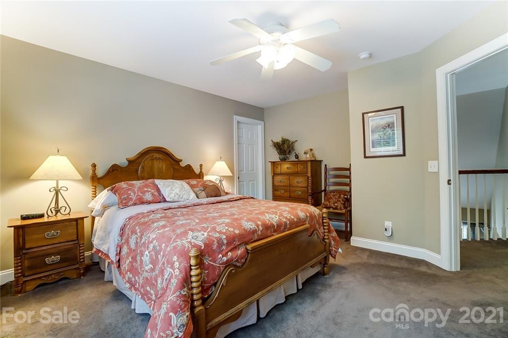 1100 Blacksnake Road Stanley, NC 28164 - Photo 28 of 48 a bedroom with a bed and a chandelier