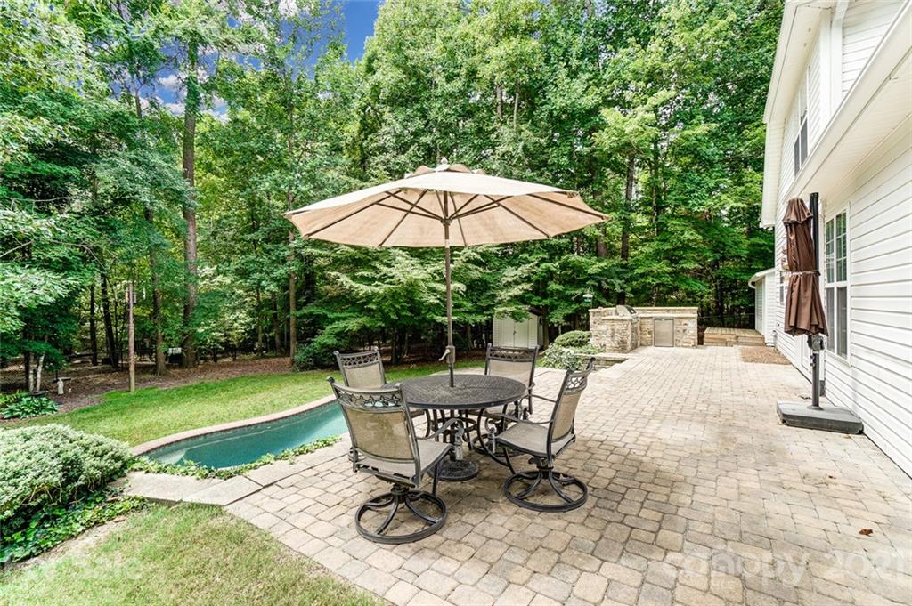 1100 Blacksnake Road Stanley, NC 28164 - Photo 42 of 48 a view of a backyard with table and chairs under an umbrella