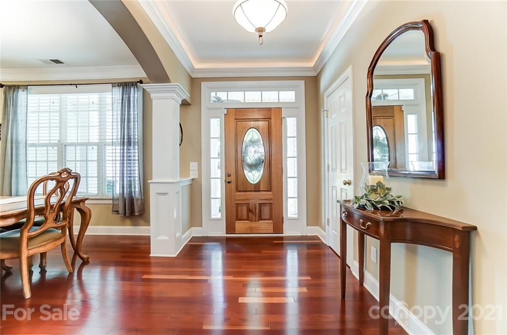 1100 Blacksnake Road Stanley, NC 28164 - Photo 6 of 48 a dining room with wooden floor potted plants and a chandelier