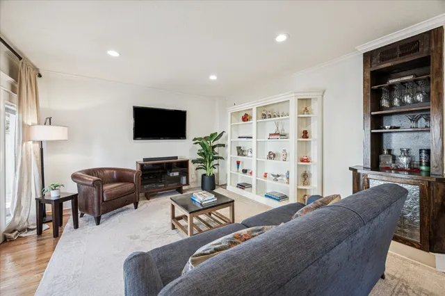 a living room with furniture a flat screen tv and a large window
