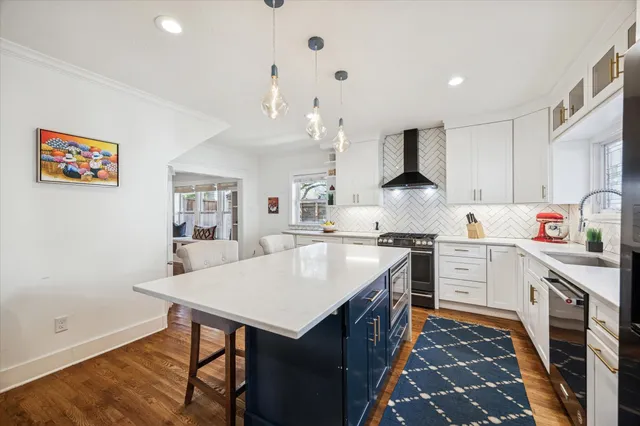 a kitchen with stainless steel appliances kitchen island granite countertop a stove and a view of living room