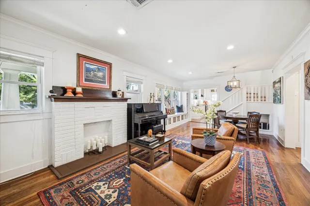 a view of a dining room with furniture a rug and wooden floor