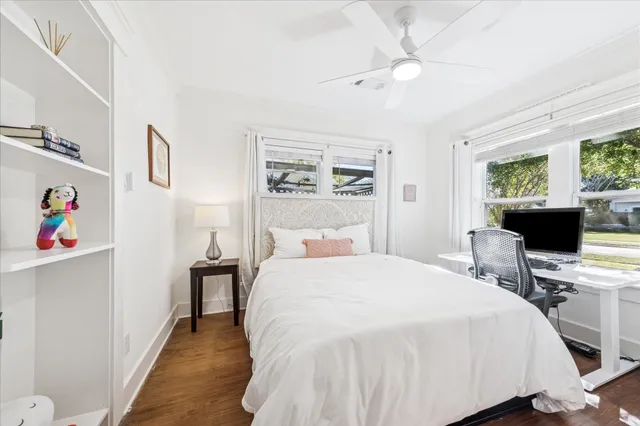 a bedroom with a bed tv and a window