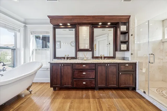 a bathroom with a granite countertop sink a mirror and a shower