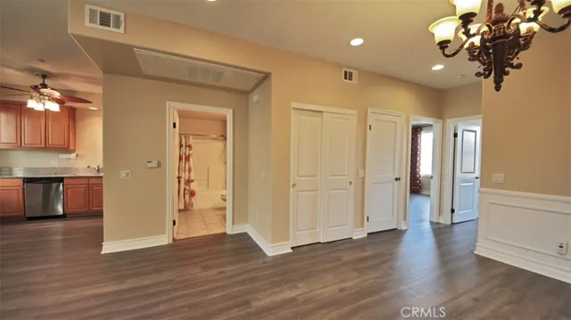 a view of a hallway with wooden floor and chandelier
