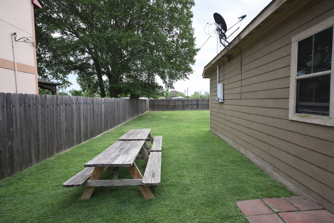 250 7th Street Hempstead, TX 77445 - Photo 22 of 26 a view of a backyard with wooden fence and a bench