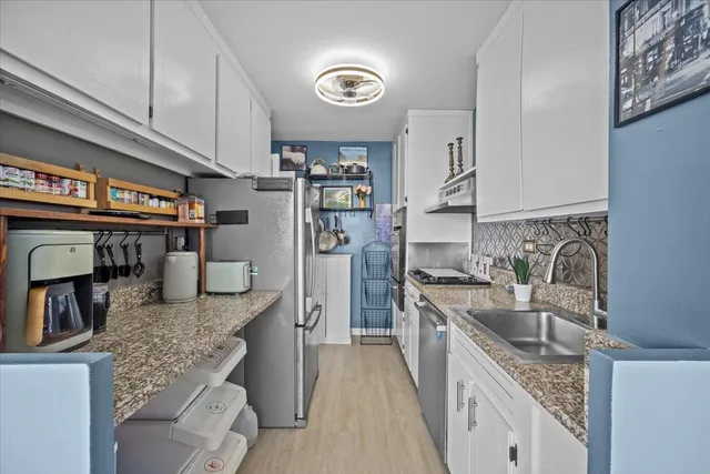 a kitchen with stainless steel appliances granite countertop a sink stove and refrigerator