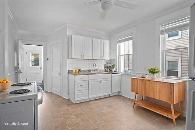 a kitchen with white cabinets and white appliances