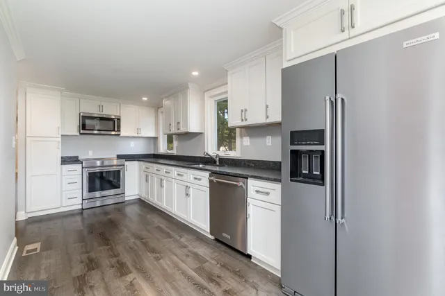 a kitchen with stainless steel appliances granite countertop a refrigerator a stove top oven a sink and dishwasher