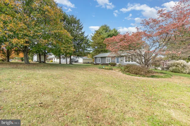 a view of a house with a yard and tree s