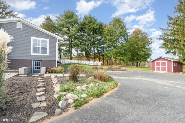 a view of house with yard and trees in the background
