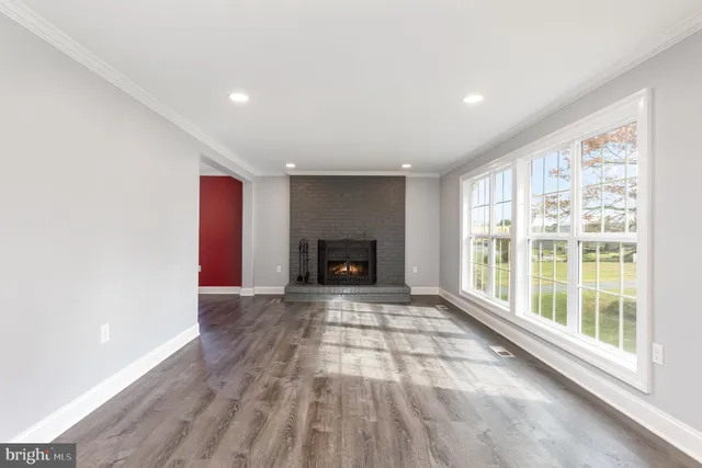 a view of an empty room with a window and a fireplace