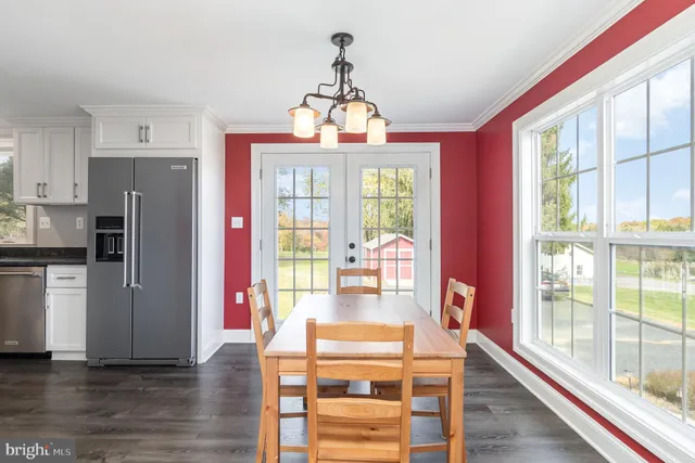 a view of a dining room with furniture a chandelier and wooden floor