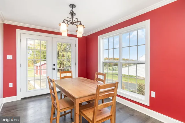 a view of a dining room with furniture large windows and wooden floor