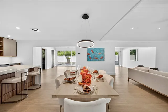 a living room with furniture kitchen view and a large window