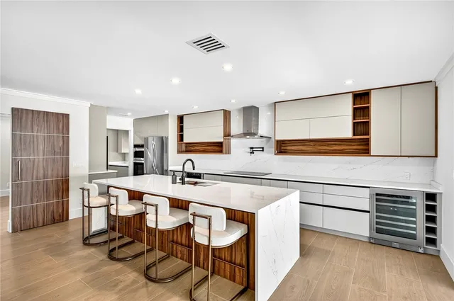 a kitchen with stainless steel appliances a stove a sink cabinets and a refrigerator