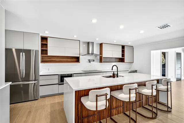 a kitchen with granite countertop a table chairs microwave and refrigerator