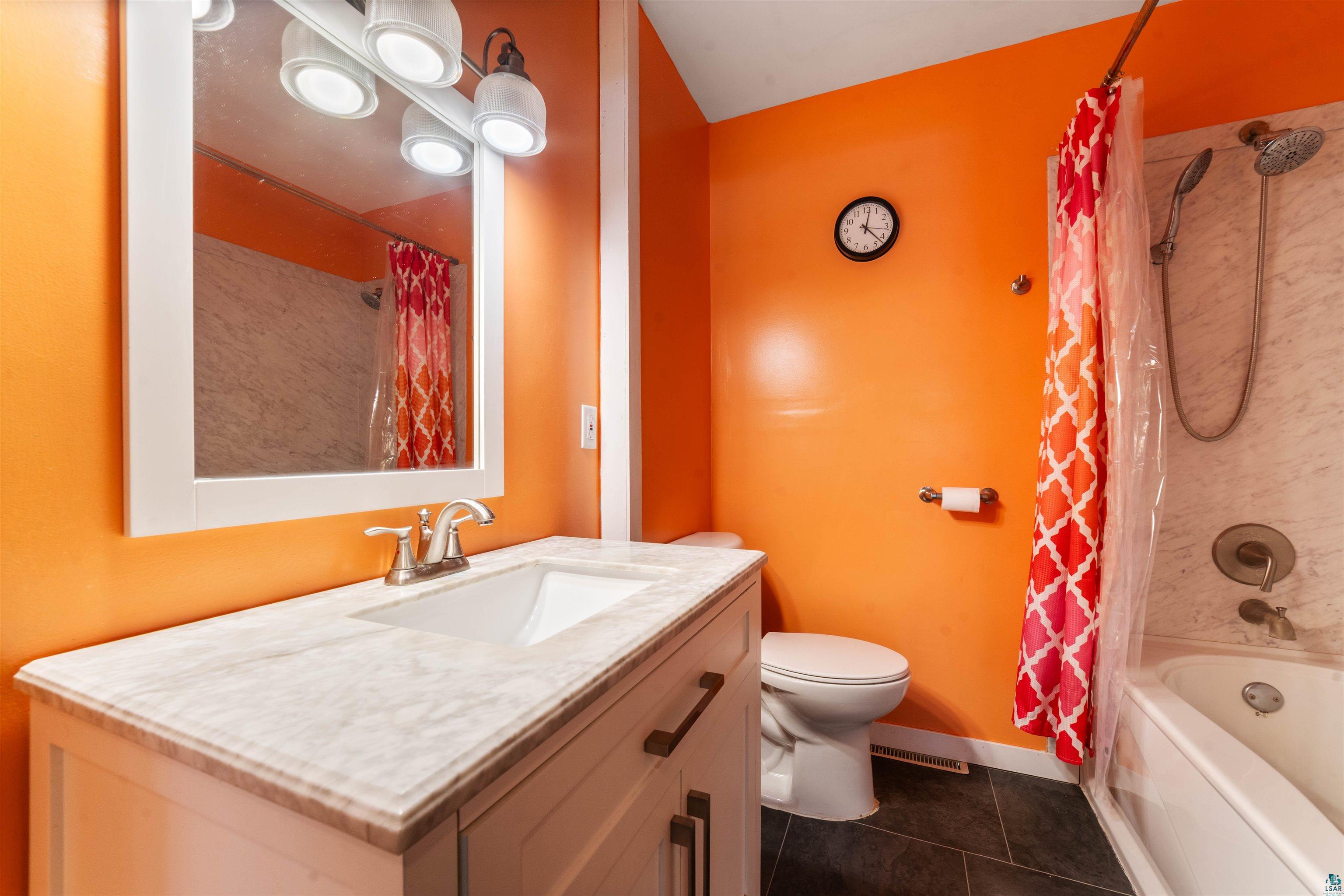 5716 North Pike Lake Road Duluth, MN 55811 - Photo 14 of 31 Full bathroom with shower / bath combo with shower curtain, vanity, tile patterned floors, and toilet