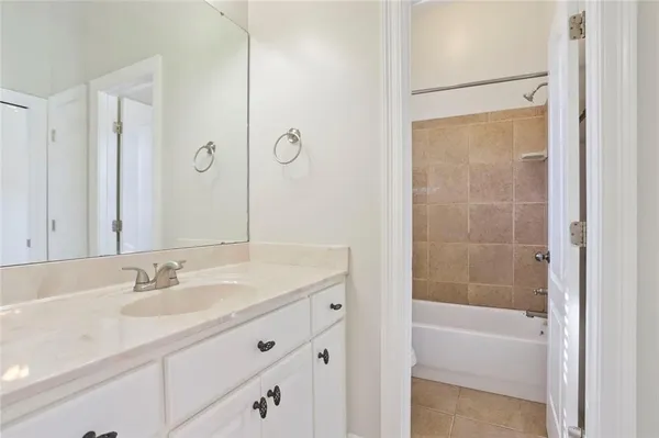a bathroom with a shower sink vanity and mirror