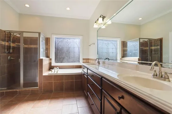 a bathroom with a granite countertop sink a large mirror and a bathtub