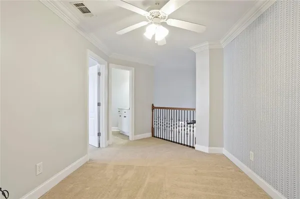 en empty room with windows and ceiling fan