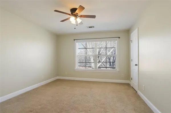 an empty room with a window and a fan