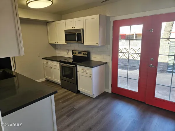 a kitchen with stainless steel appliances granite countertop a stove a sink and a microwave