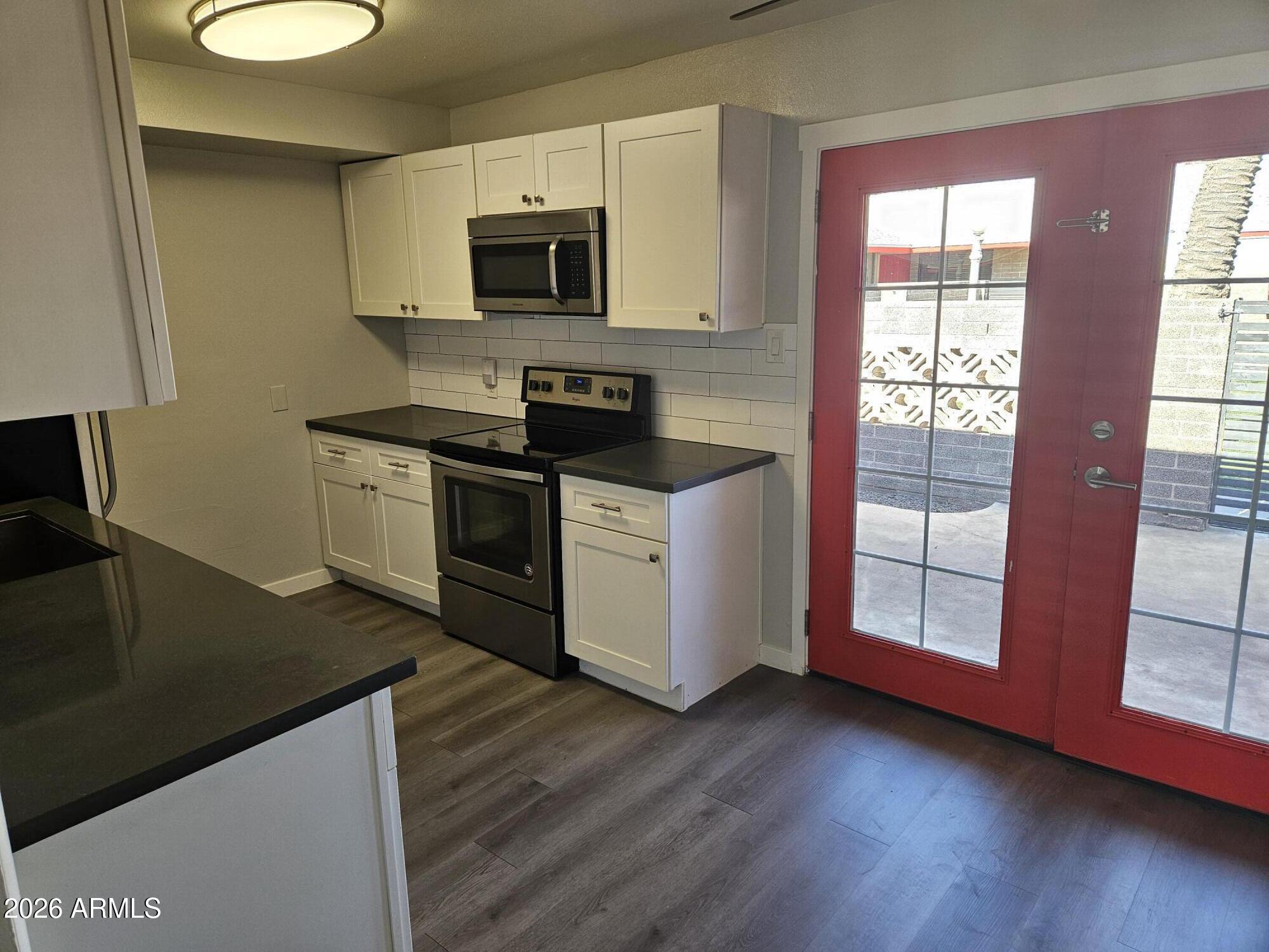 324 West Pasadena Avenue, Unit 8 Phoenix, AZ 85013 - Photo 5 of 22 a kitchen with stainless steel appliances granite countertop a stove a sink and a microwave