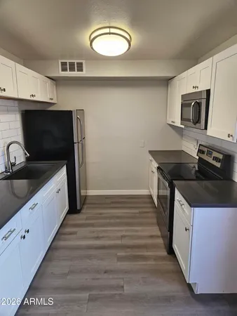 a kitchen with granite countertop a sink and a stove top oven