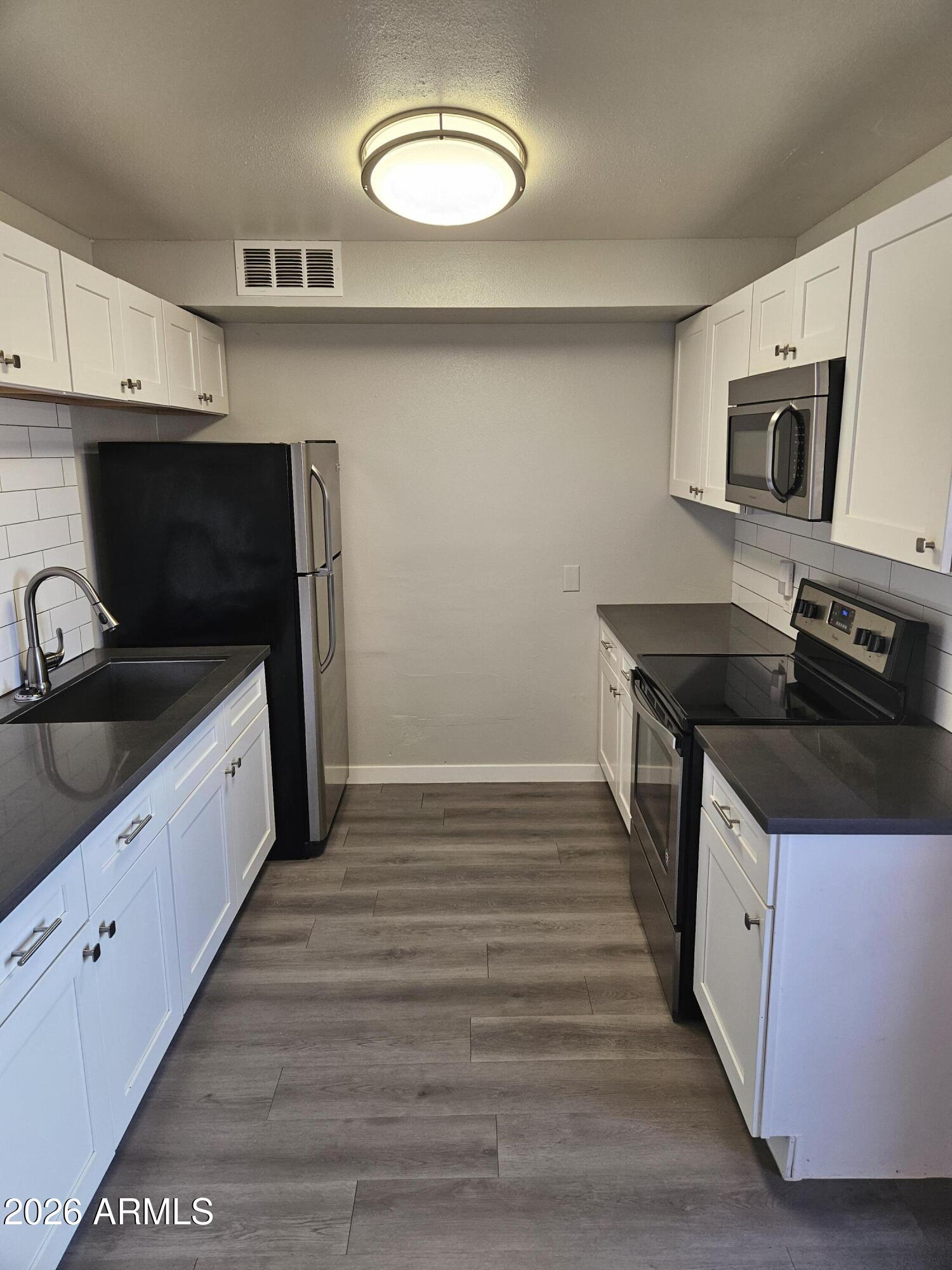 324 West Pasadena Avenue, Unit 8 Phoenix, AZ 85013 - Photo 6 of 22 a kitchen with granite countertop a sink and a stove top oven