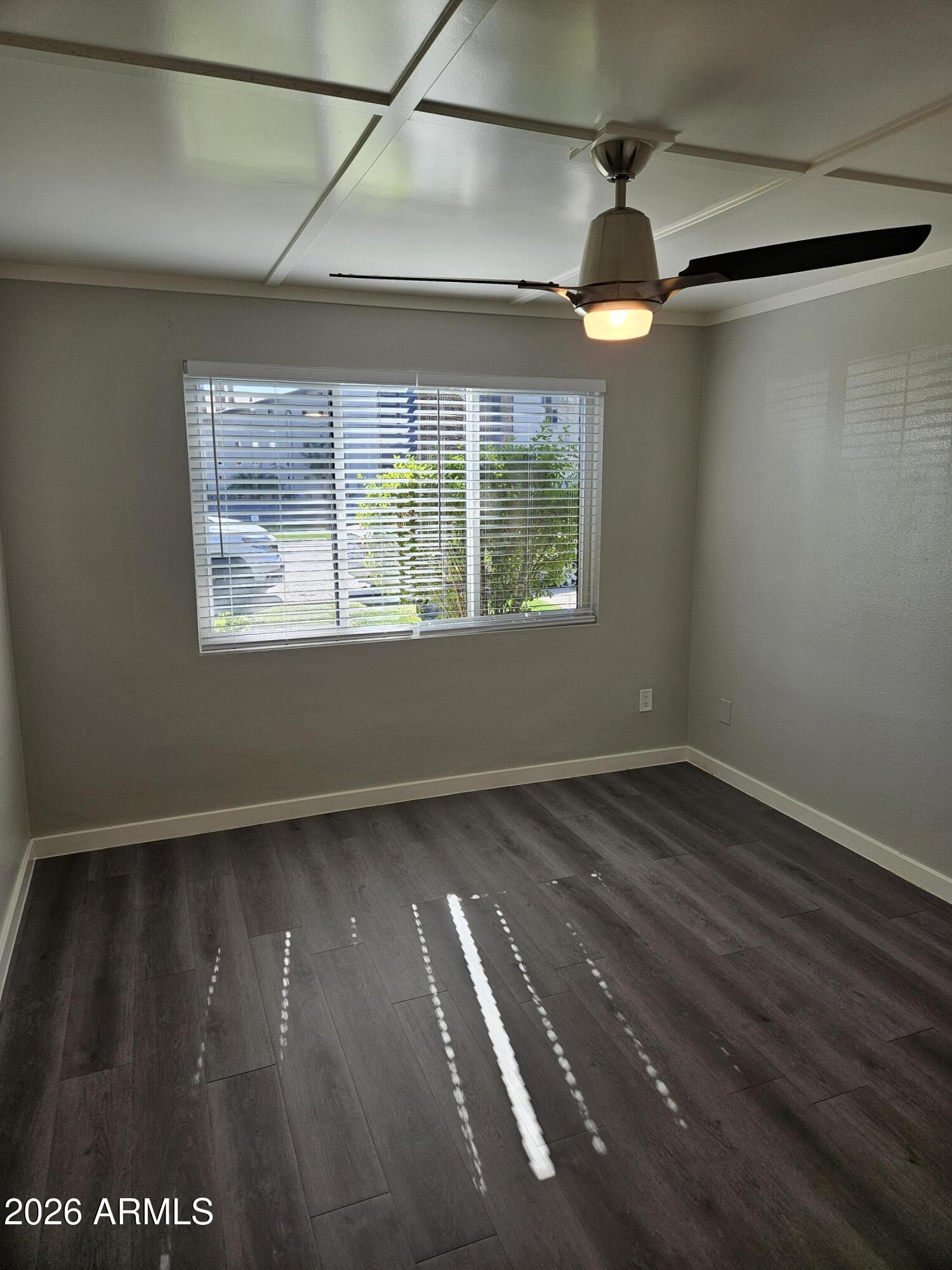 324 West Pasadena Avenue, Unit 8 Phoenix, AZ 85013 - Photo 10 of 22 a view of an empty room with wooden floor and a window