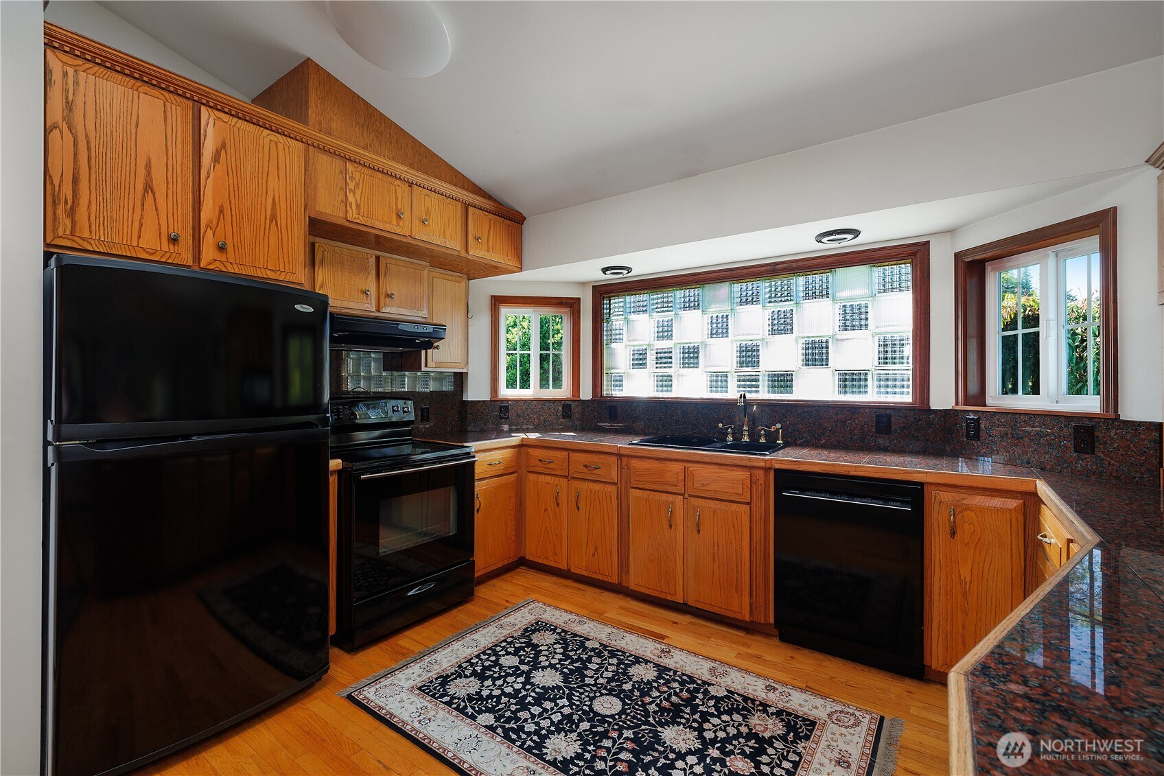 5629 Sleater Kinney Road Northeast Olympia, WA 98506 - Photo 16 of 32 a kitchen with granite countertop stainless steel appliances and wooden cabinets