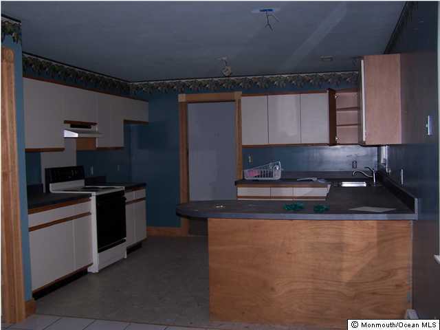 591 Reed Road Jackson, NJ 08527 - Photo 2 of 3 a kitchen with granite countertop a sink a stove and refrigerator