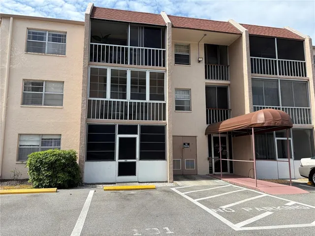 a front view of a building with a window and a yard