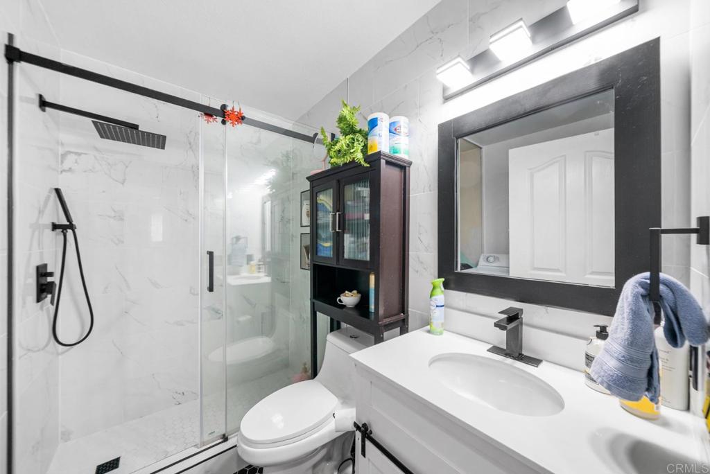 500 Telegraph Canyon Road, Unit H Chula Vista, CA 91910 - Photo 21 of 36 a bathroom with a granite countertop sink toilet a mirror and shower