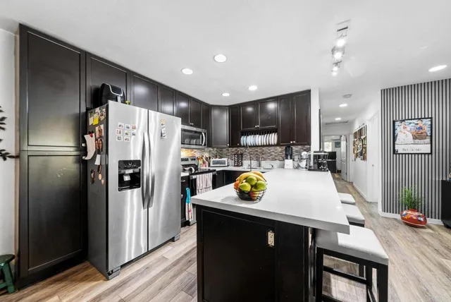 a kitchen with refrigerator and chairs