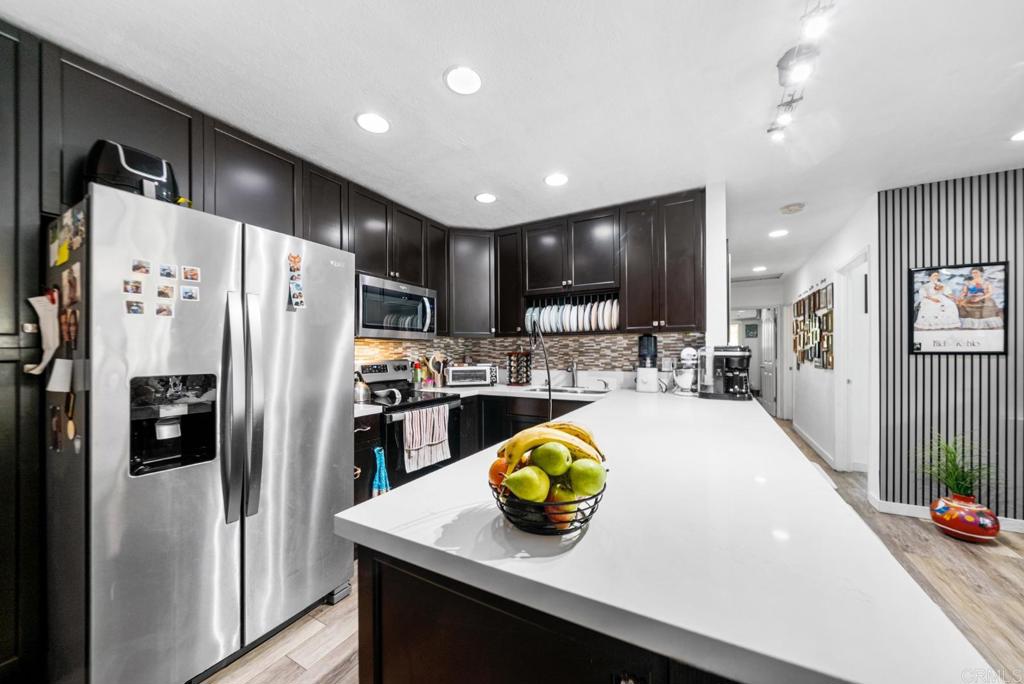 500 Telegraph Canyon Road, Unit H Chula Vista, CA 91910 - Photo 6 of 36 a kitchen with a sink a refrigerator and chairs