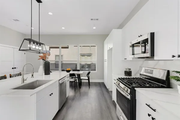 a kitchen with stainless steel appliances a stove a microwave cabinets and a counter space