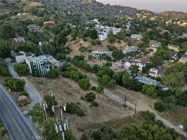 an aerial view of residential house with outdoor space and trees all around
