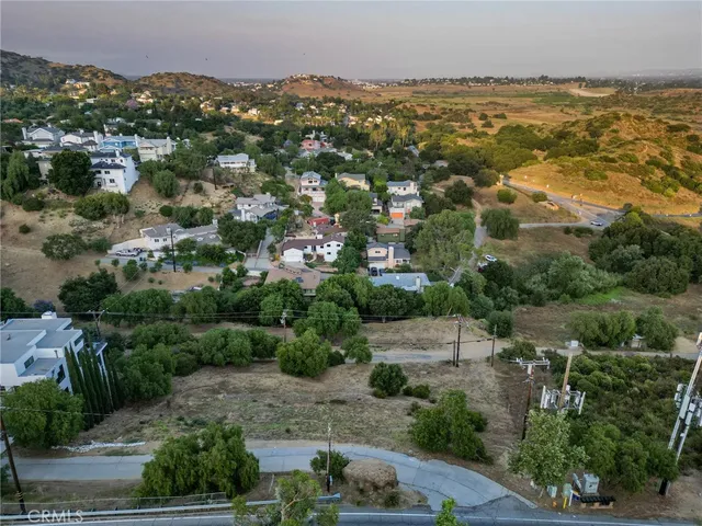 an aerial view of residential houses with outdoor space and trees