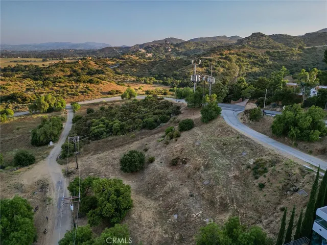 an aerial view of residential houses with outdoor space and trees