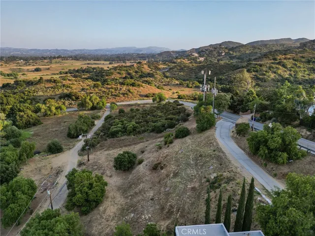 an aerial view of residential houses with outdoor space and trees