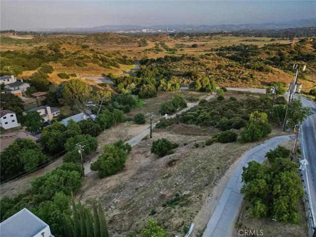 an aerial view of residential houses with outdoor space and trees