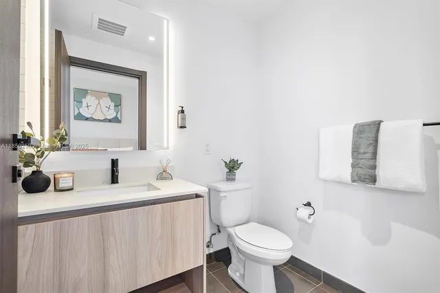 a bathroom with a toilet a sink and mirror